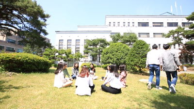 학생들이 학교 내 잔디에 둘러앉아 있는 모습.